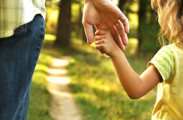 A child reaches for an adult's hand